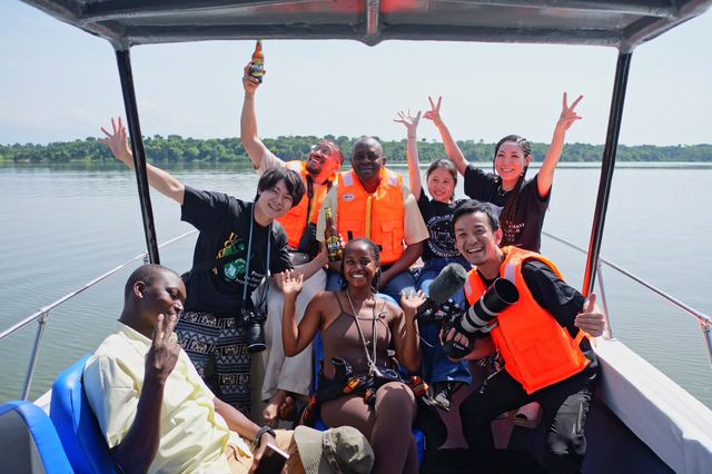 A mixed Ugandan and Japanese group in life vests on a boat tour on the River Nile