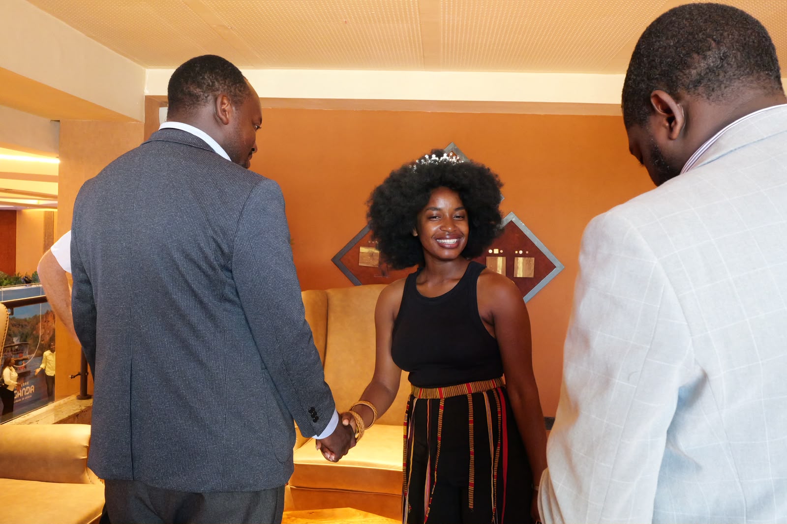 Ugandan and Japanese delegates shaking hands, symbolizing the bilateral partnership
